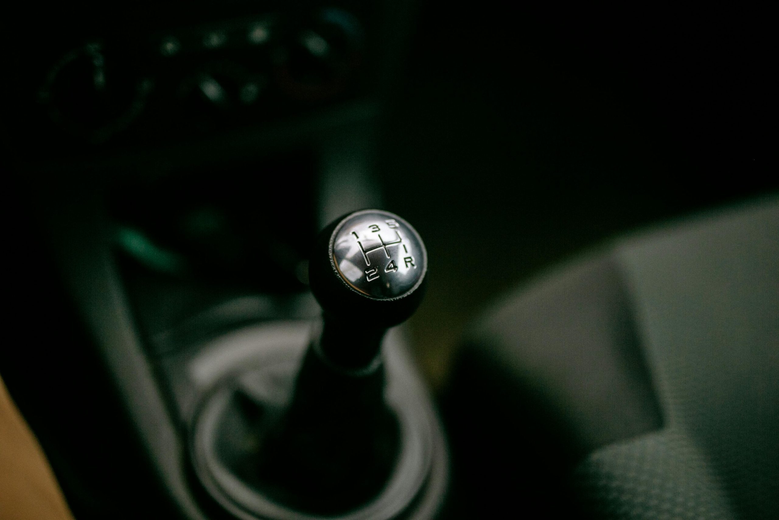 Detailed view of a manual gear shifter inside a vehicle, with a focus on the gear shift knob.